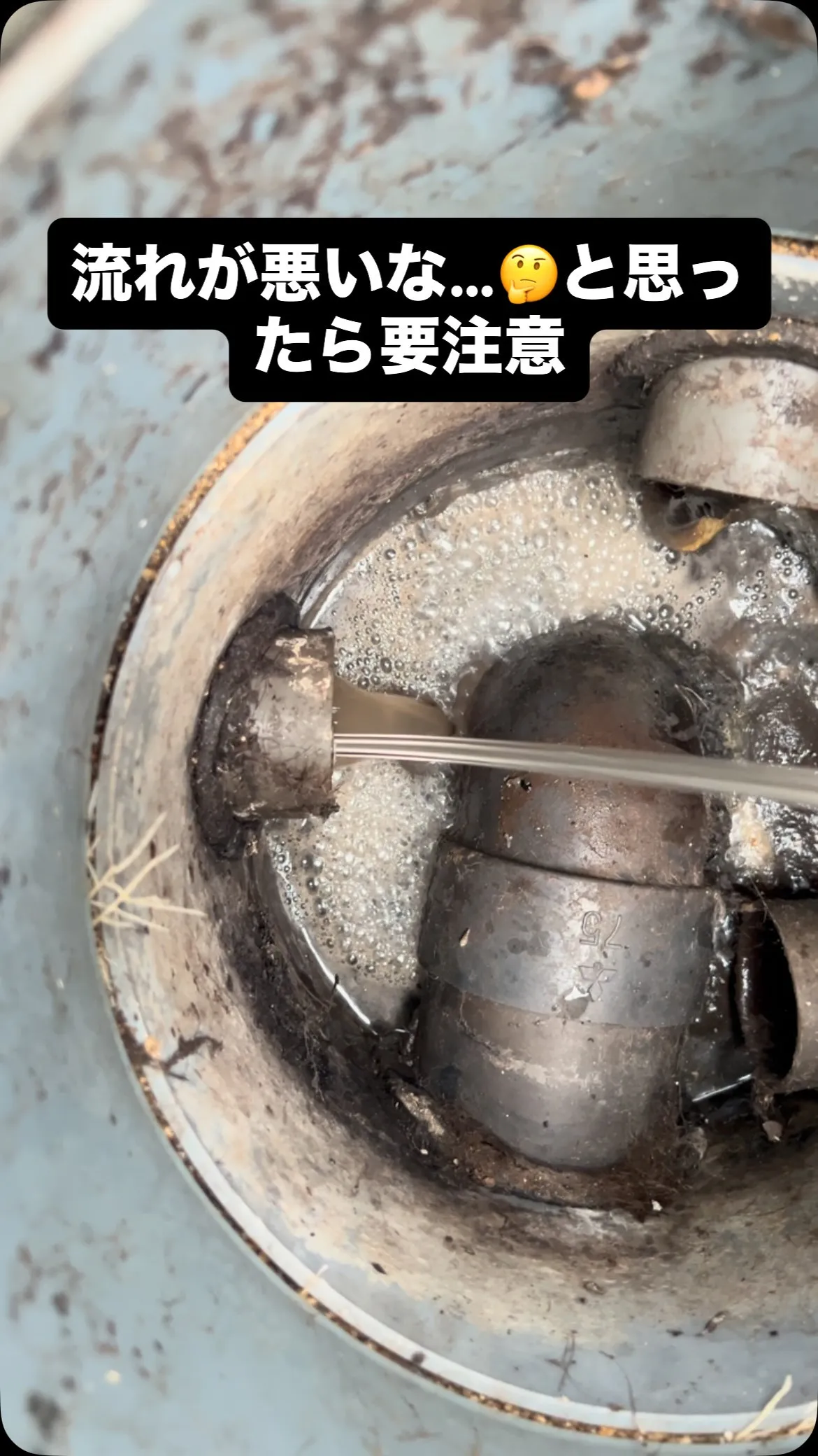 写真のように排水が詰まり、シンク下から泡と水があふれている状...